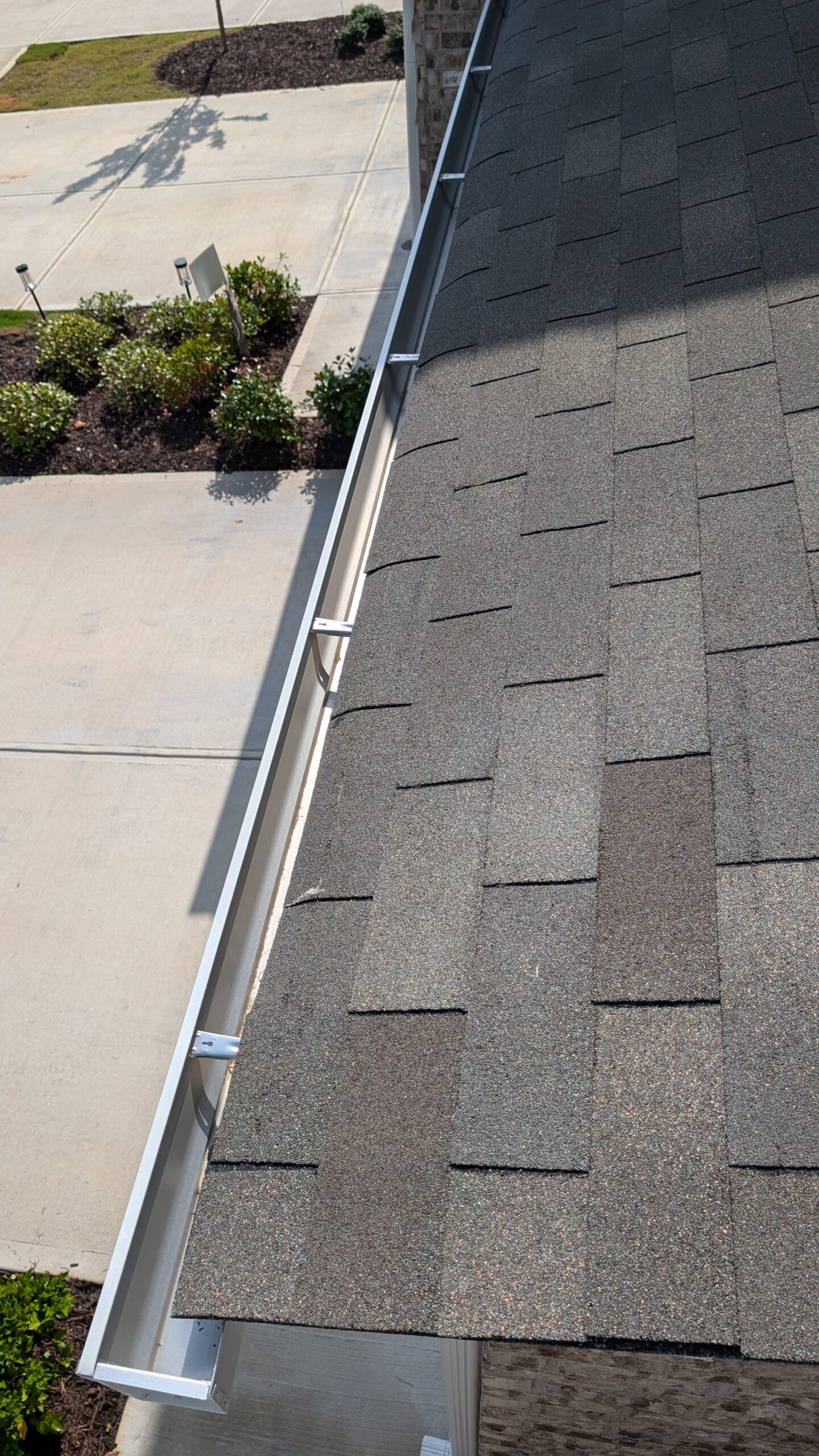 Clogged gutters full of pine needles and debris before cleaning